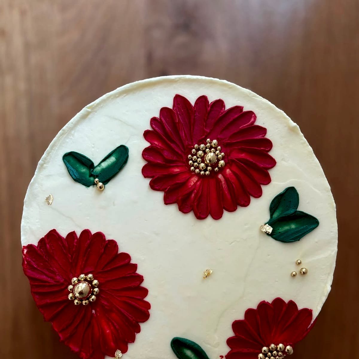 Layer cake décoré de fleurs rouges en crème